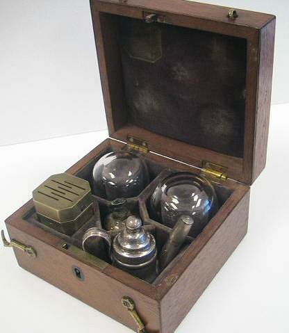 Savigny & Co. temple cupping set c.1840, London England.  Note the comparison above between a standard cupping set and the very diminutive size of the temple set.  The set contains a 6-bladed scarificator, two small cups, a silver teapot style burner for warming the glasses and a small cut glass bottle with alum for packing the cuts to stop the bleeding.