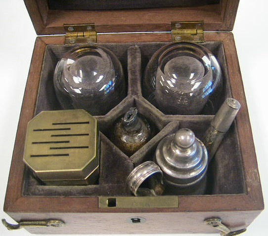 Savigny & Co. temple cupping set c.1840, London England.  Note the comparison above between a standard cupping set and the very diminutive size of the temple set.  The set contains a 6-bladed scarificator, two small cups, a silver teapot style burner for warming the glasses and a small cut glass bottle with alum for packing the cuts to stop the bleeding.