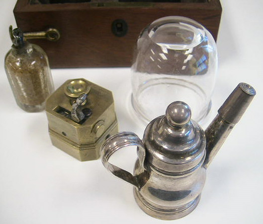 Savigny & Co. temple cupping set c.1840, London England.  Note the comparison above between a standard cupping set and the very diminutive size of the temple set.  The set contains a 6-bladed scarificator, two small cups, a silver teapot style burner for warming the glasses and a small cut glass bottle with alum for packing the cuts to stop the bleeding.