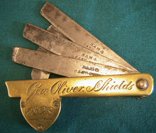 Three blade brass fleam inscribed Geo Oliver Shields.  The blade basket is an unusual brown horn insert.  The mark BAM with an iron cross is that of Jonathan Sutton of Meadow Street in Sheffield England.