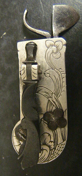 Beautiful white metal spring lancet probably Swiss in origin c. 1820-1830.  Note the beautiful floral design to the set screw holding the blade in place and the raised shell pattern to the nail-nick used to remove the back panel.  The piece is double marked Loneblad.