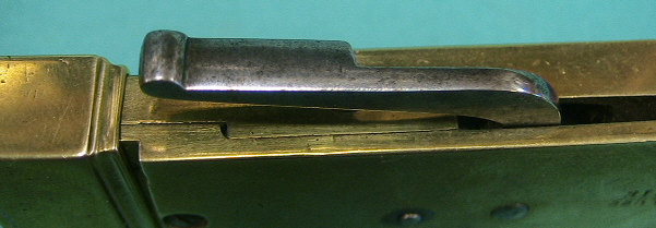 Rare form spring lancet marked with the Simpson mark and the 55 Strand address.  The instrument is armed by pulling the handle back to a half point that allos depth adjustment wiht the turn screw on the side.  After the depth has been set the arm is pulled all t he way back rotating the blade into an armed position.  The handle drops back into the starting position and is released by depressing the handle while holding the instrument with a "pen" grip.