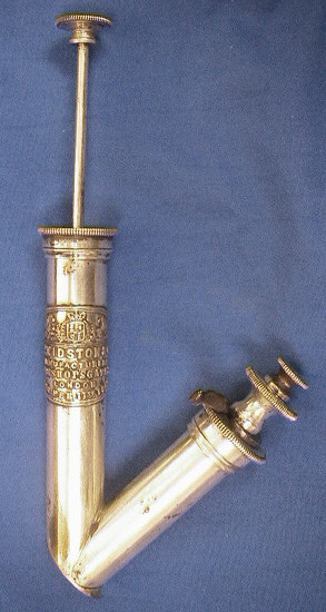 This artificial leech is plated brass.  The plunger to the left is spring loaded to allow the creating of a vaccuum when depressed and the foot of the item is applied to the skin.  When the plunger is released the draw is created.  The right tube contains a spring driven blade that is released with the depression of the lever.  The item is marked as Kidston & Co Manufacturers, 18 Bishopsgate, London, Reg. Feb 11th 1850.
