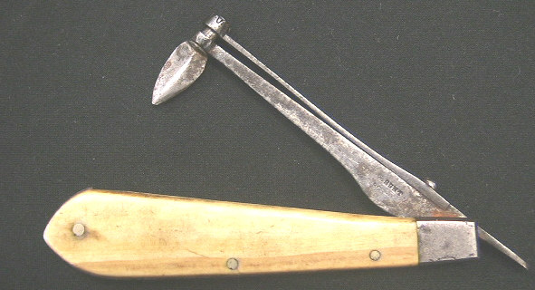 Small folding fleam with horn scales.  The item is marked Hunt Boston.  This very diminutive tool has a spring steel loaded back that allows you to drop the retaining cuff down and rotate the blade 360 degrees.  I am not certain this item had any use in the bloodletting field, it may very possibly be a gum lancet based on the size and the versatility of blade direction.