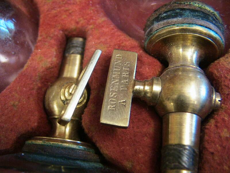 The scarificator pictured above is a very unusual item.  Unlike the common blade mechanisms seen in most cupping sets.  This unit contains 8 metal spikes on a brass plate.  The entire plate can be raised or lowered by turning the plunger.  The base is spring-loaded and would depress into the patient with pressure on the top plunger.  A set with an identical scarificator is in the collection of Doug Arbittier, his is marked by an Italian maker, Lollini.  